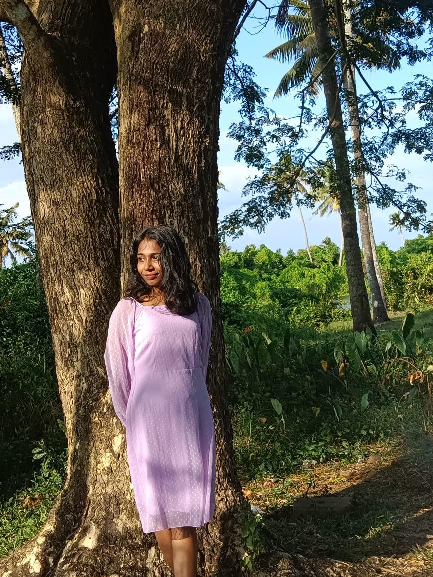Person standing by a large tree.
